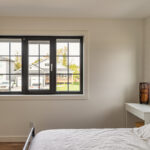 Passive House tilt and turn black windows in this bedroom.