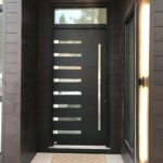 custom entrance door in black with eight small horizontal window openings and a beautiful stainless steel pullbar