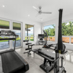 Home Gym with oversized windows and a large garden door that leads out onto the deck.