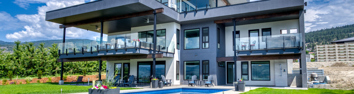 Under the striking blue sky stands the modern 2 story home with a outdoor swimming pool.