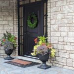 Black elegant, yet somewhat traditional looking main door with a sidelight on either side and a transome.