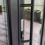 Meticulous crafted black exterior doors, includes striking black handlebar and electric key pad.