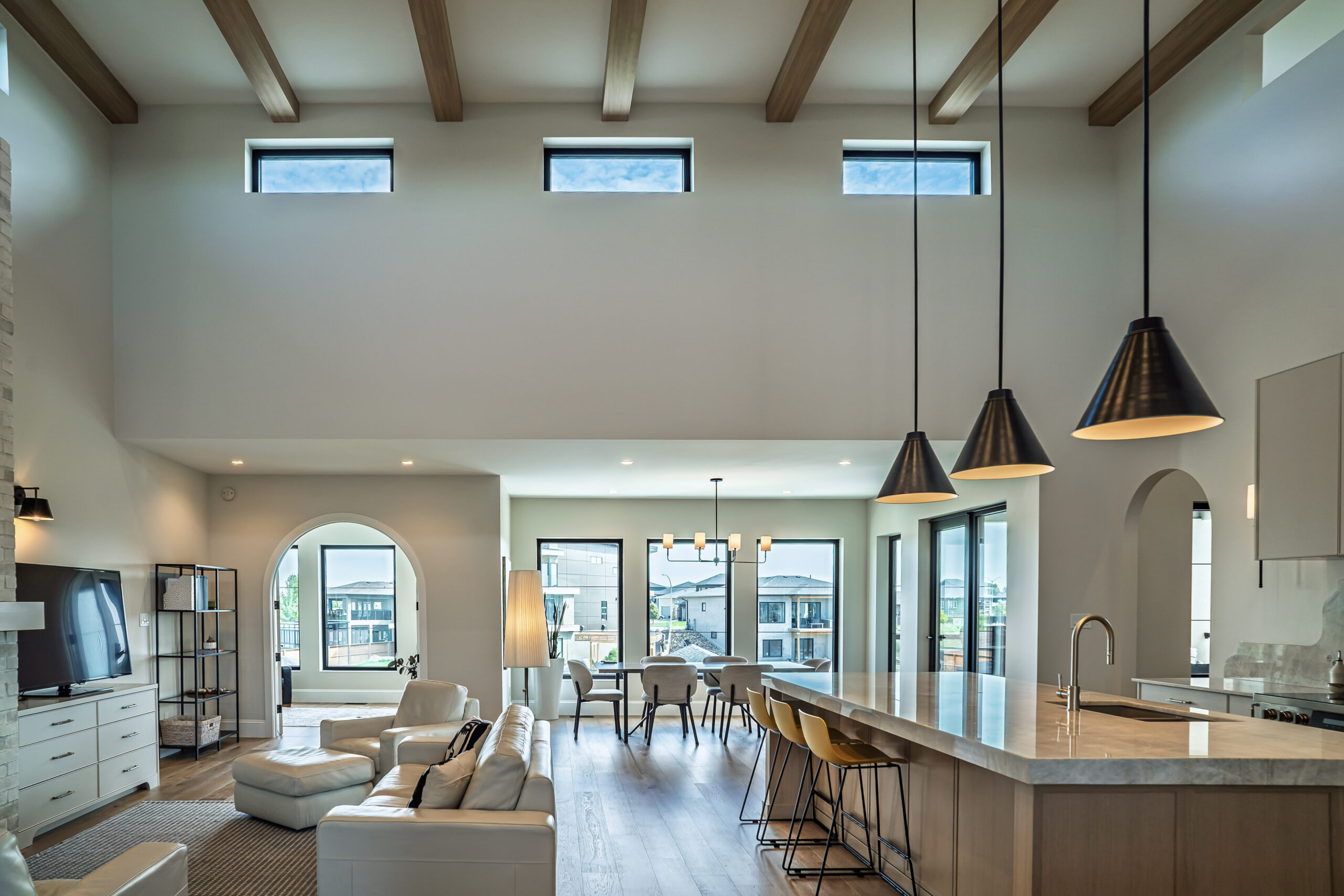 Modern prairie-style luxury home with oversized energy-efficient windows, black window frames, and an open- concept living space.